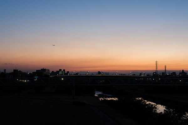 夕焼けの矢田川と飛行機
